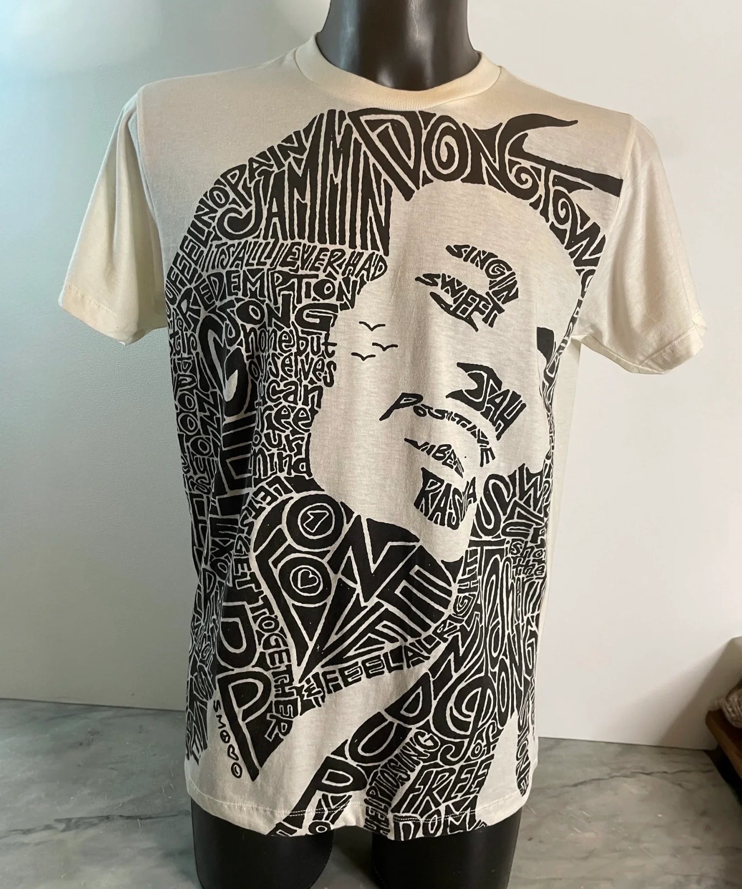 Maglietta ql maglie grafica tipografica, ritratto stilizzato e titoli canzoni, su manichino.