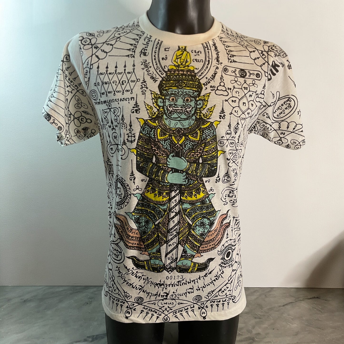 Maglietta unisex bianca in cotone con stampa raffigurante una divinità orientale protettiva e simboli mistici thailandesi in stile Sak Yant, model