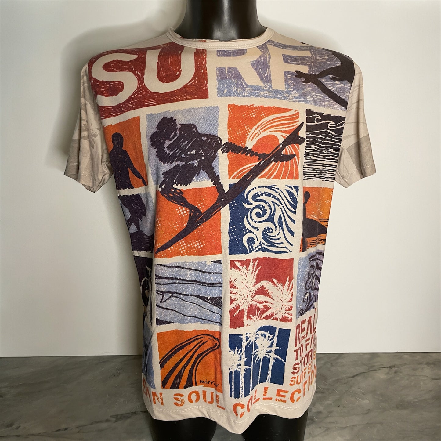 Maglietta unisex full-print “Ocean Grid” sabbia, con mosaico grafico surf vintage in arancio e blu, on model.