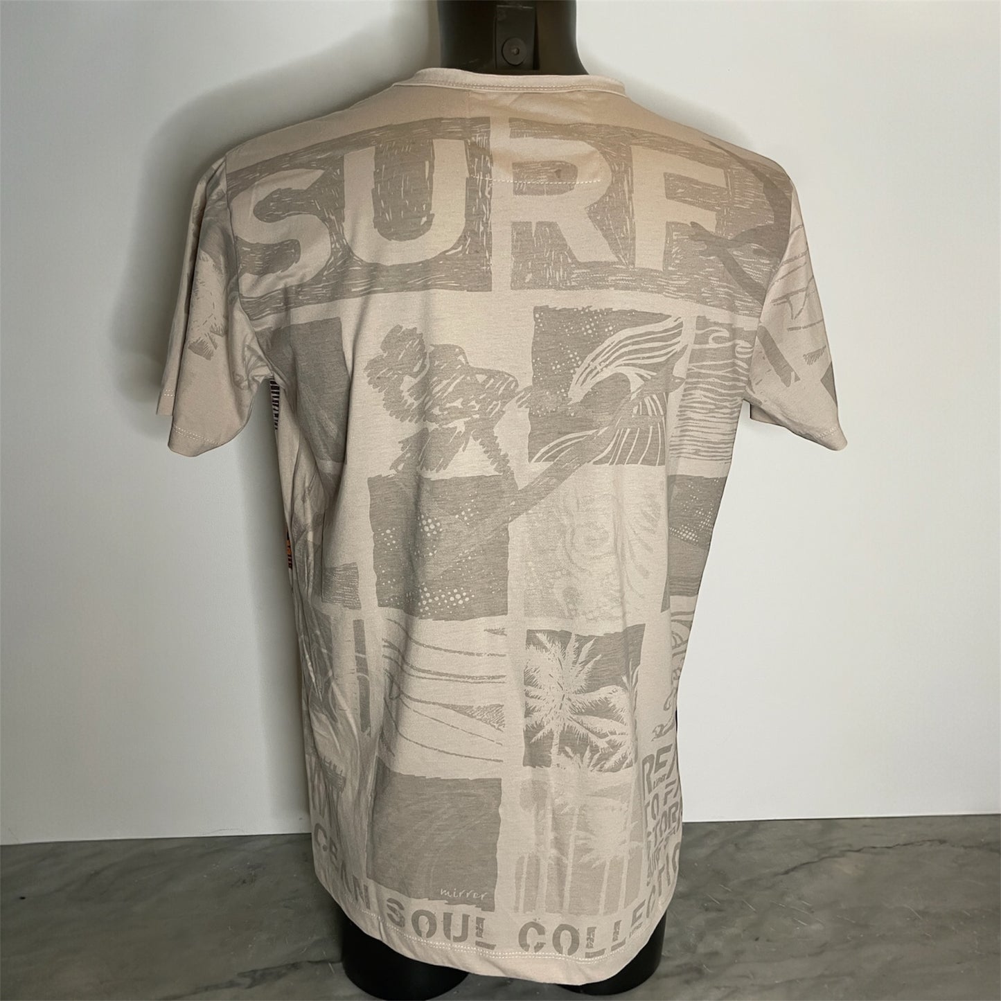 Maglietta unisex full-print “Ocean Grid” sabbia, con mosaico grafico surf vintage in arancio e blu, back on model.