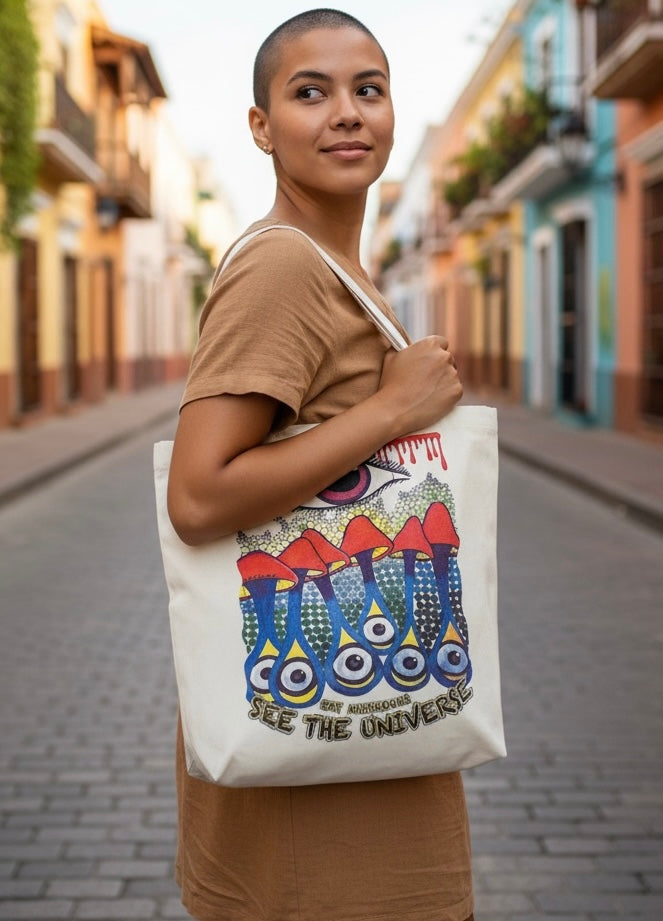 Borsa in tela di cotone grezzo con stampa psichedelica di funghi e occhi e scritta eat mushrooms see the universe, on model 