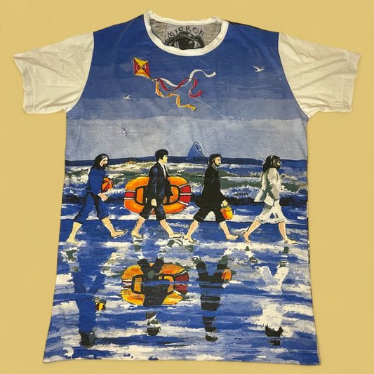 Maglietta unisex con illustrazione ironica dei Beatles che attraversano una spiaggia in stile Abbey Road