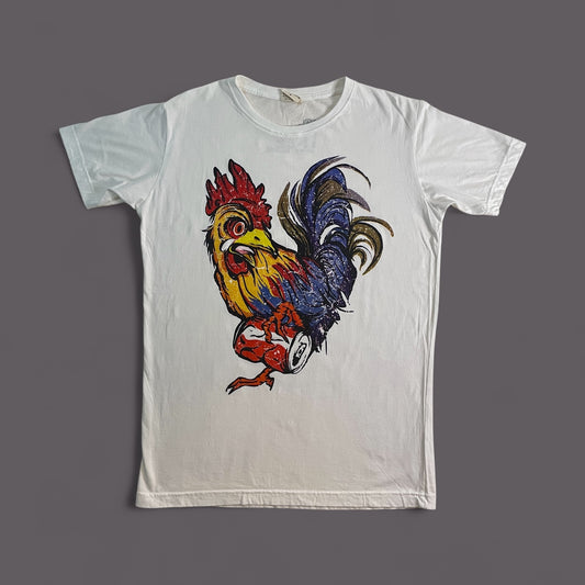 Maglietta bianca unisex in cotone con stampa artistica di un gallo colorato che calpesta una lattina.