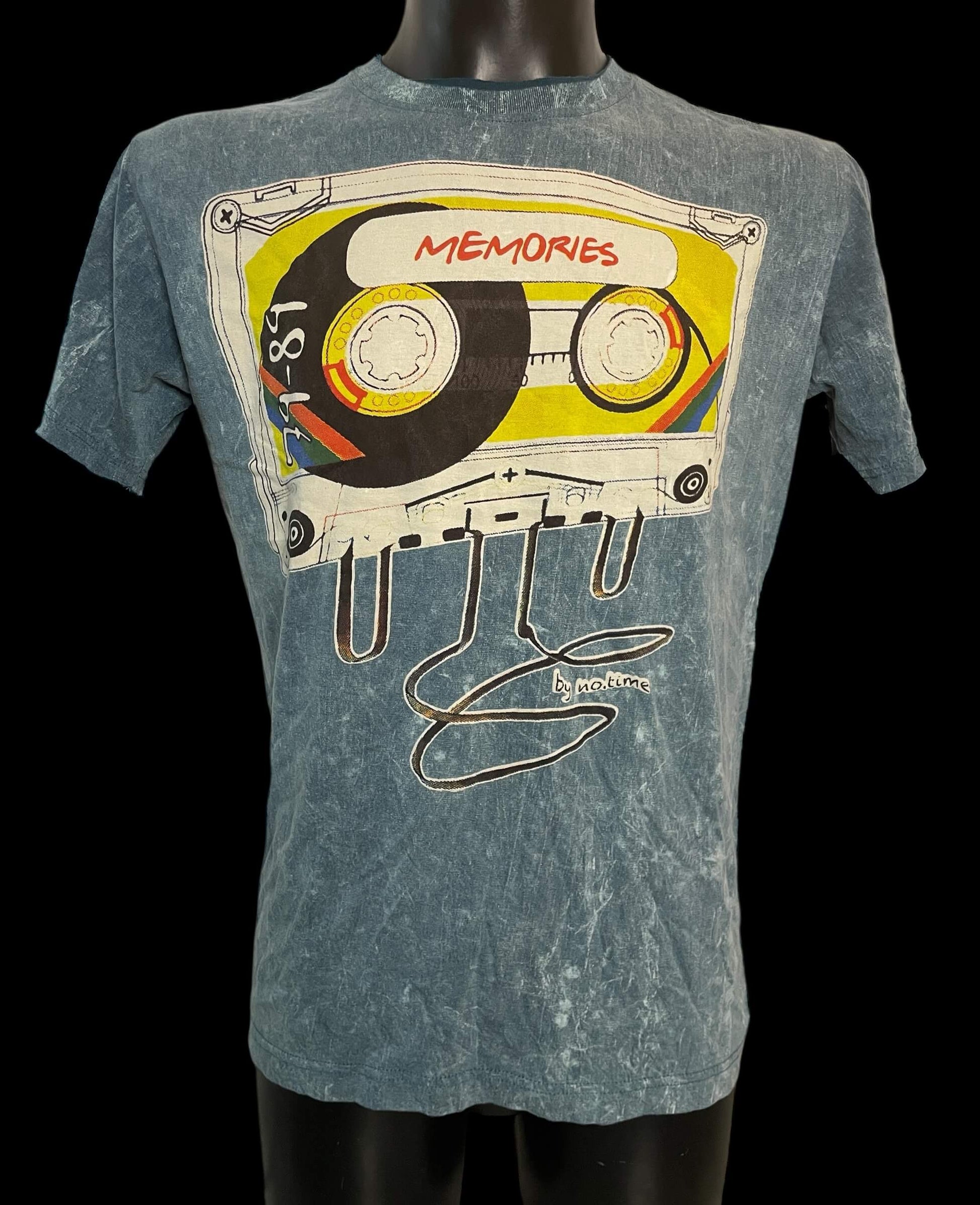 T-shirt vintage stonewash con grande stampa di una cassetta audio e scritta “Memories”, maglia unisex in cotone, esposta su manichino.