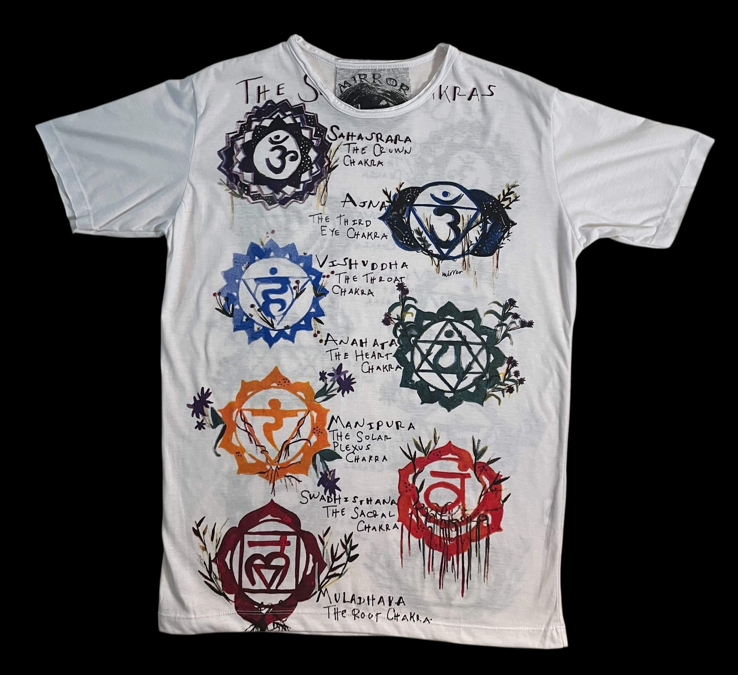 T-shirt bianca con illustrazione dei sette chakra e simboli energetici colorati, stile artistico.