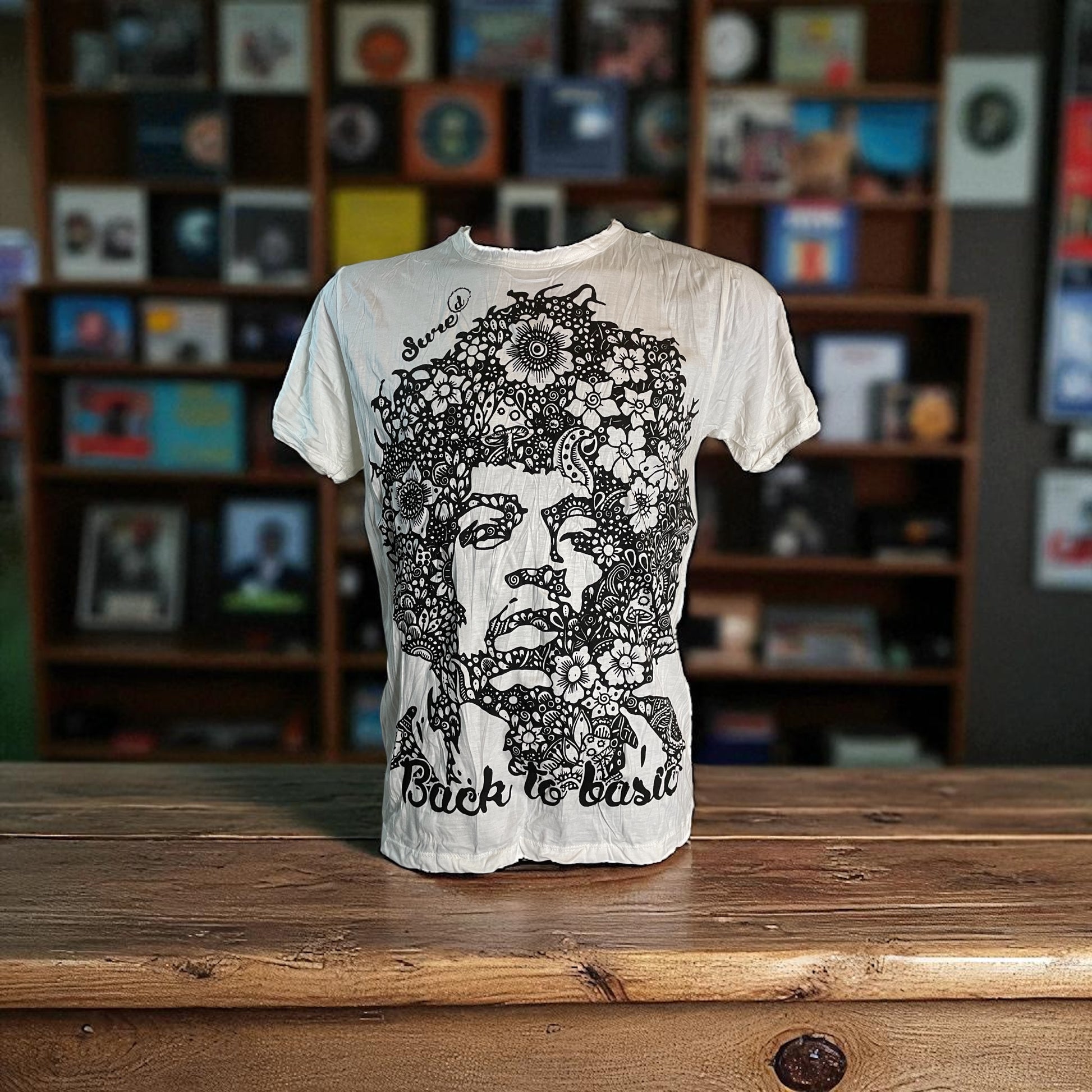 T-shirt bianca unisex con ritratto floreale di Jimi Hendrix in bianco e nero e scritta “Back to Basic” by Sure, on model 