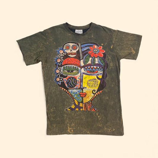 “T-shirt unisex vintage con grande grafica multicolor raffigurante un volto astratto in stile tribale-folk su sfondo scuro.”
