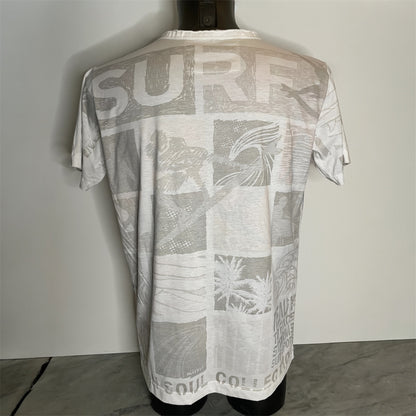 Maglietta unisex full-print “Ocean Grid” bianca, con mosaico grafico surf vintage in arancio e blu, back on model.