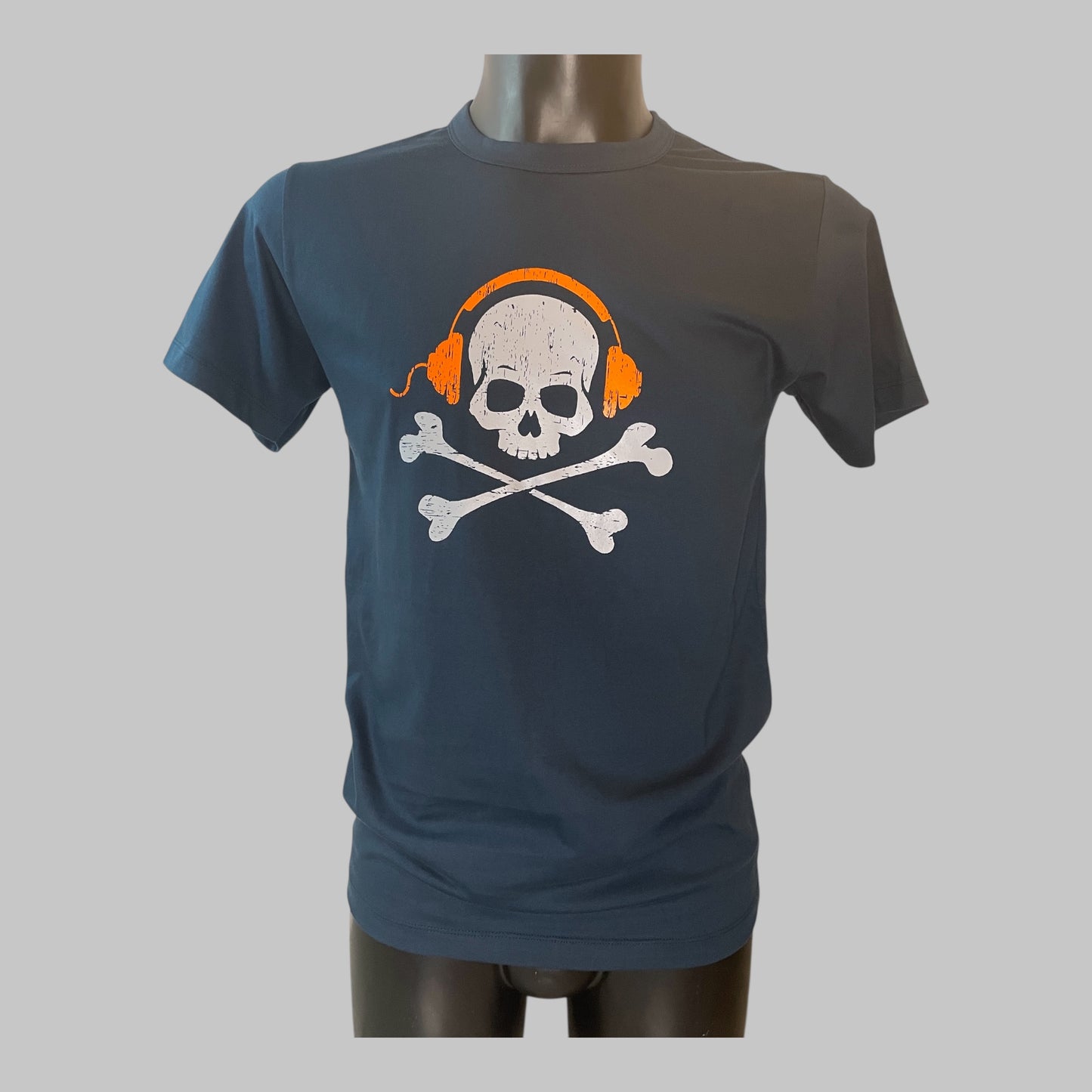 Maglietta blu unisex con grande stampa teschio vintage che indossa cuffie arancioni, grafica centrale su cotone premium, on model 1.